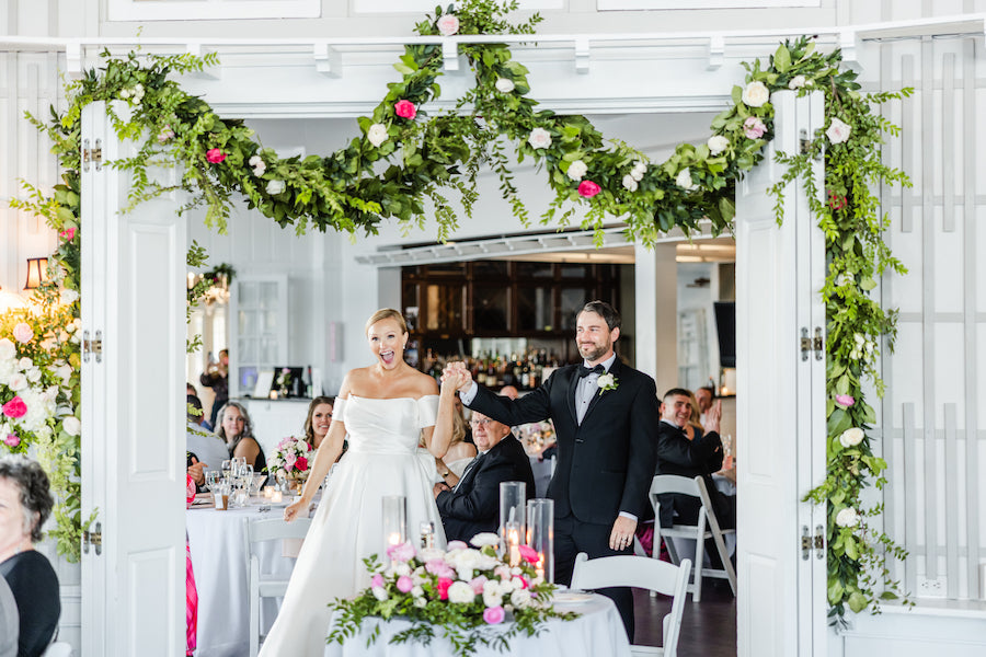 Wedding couple walking down the aisle at a decorated wedding reception.